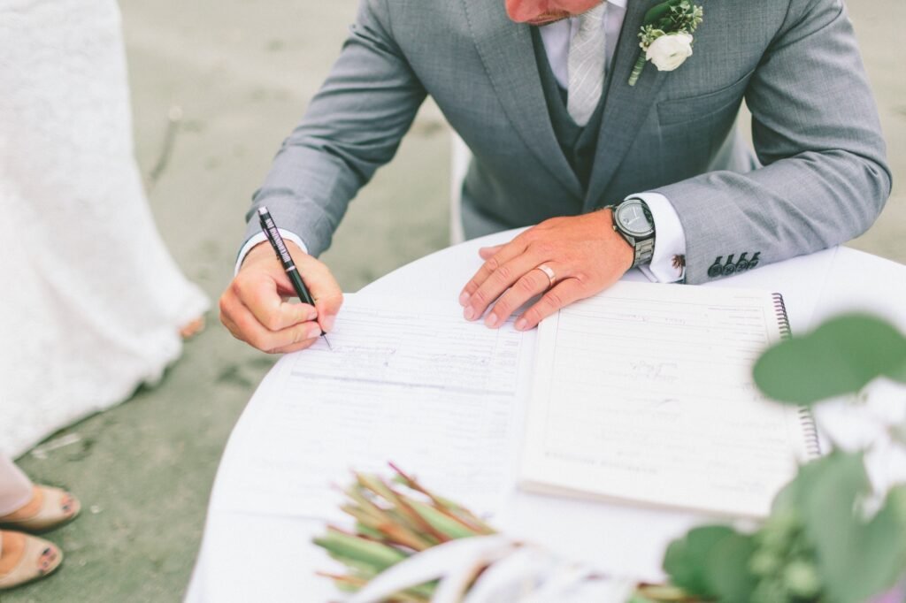A groom signing the marriage license.