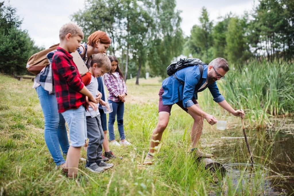 Group of school children with teacher on field trip in nature