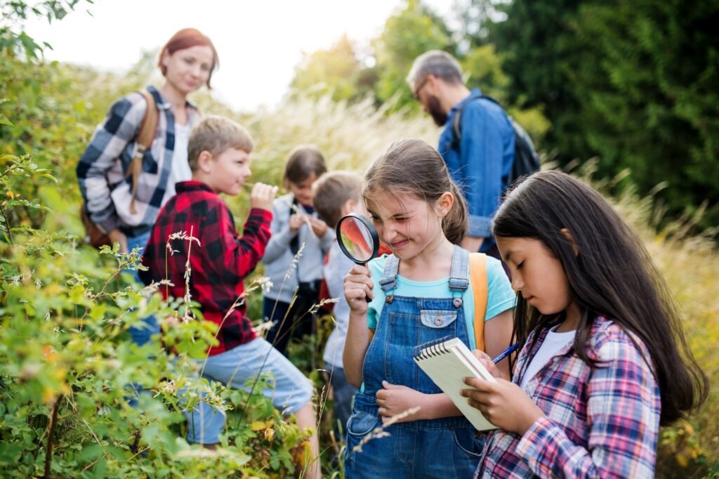 Group of school children with teacher on field trip in nature, learning science