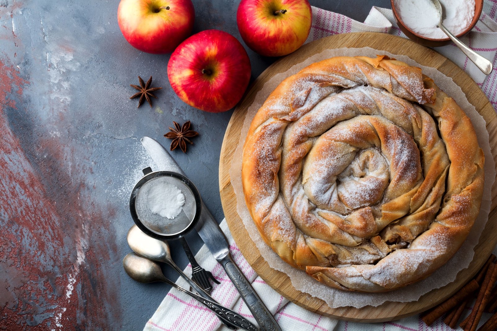 Round burek pie with an apple on a dark background. Traditional Serbian cuisine. Selective focus. To